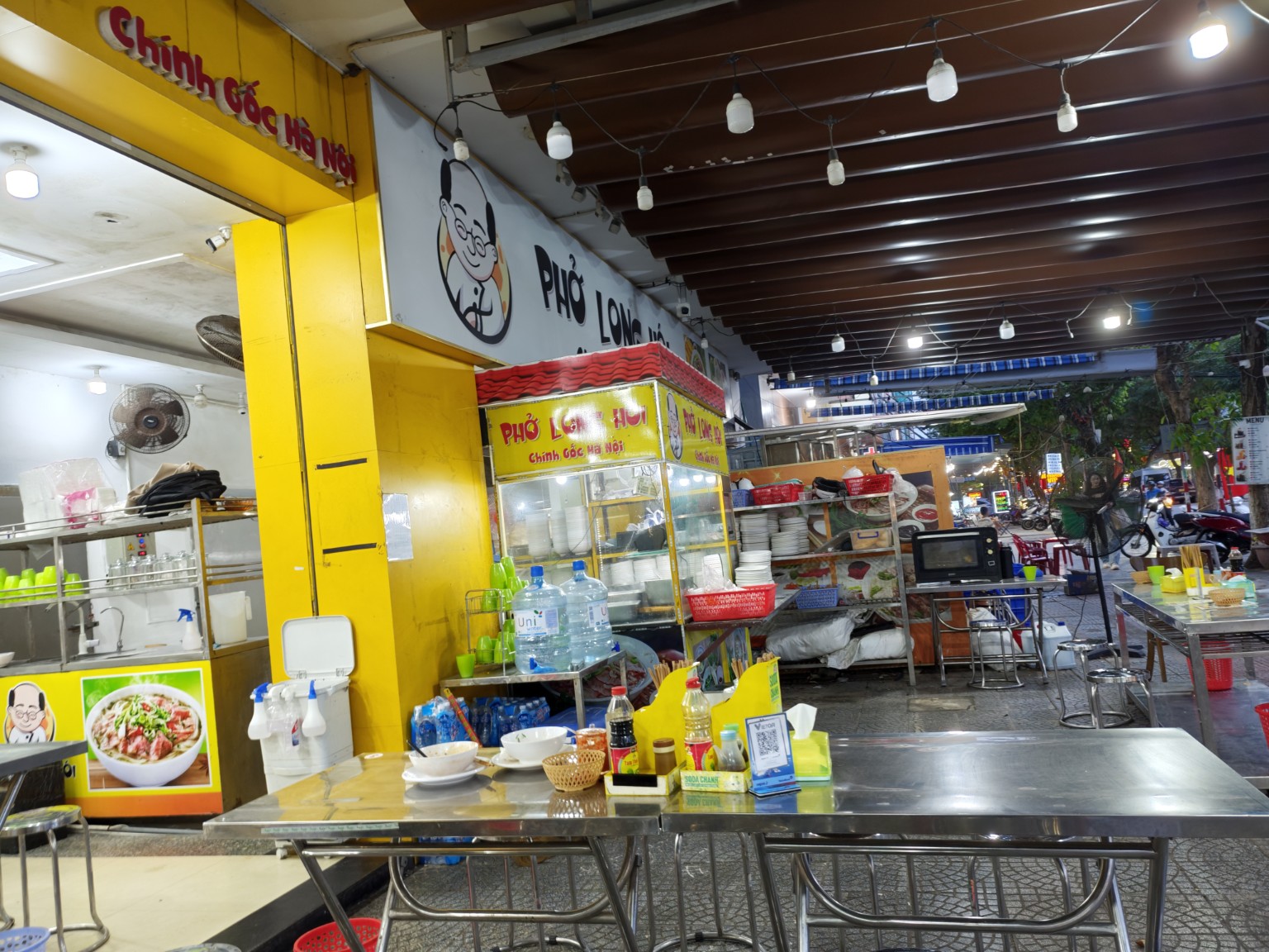 Phở Long Hội 店內實景,開放式街邊座位與不鏽鋼桌椅。