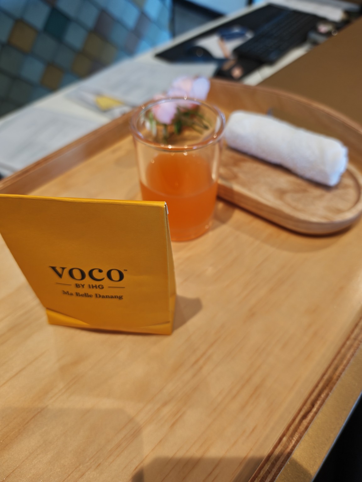 voco 的黃色小紙袋與入住時拍下的飲品。紙袋裡裝著一個小馬卡龍,記得上回好像是芒果乾。